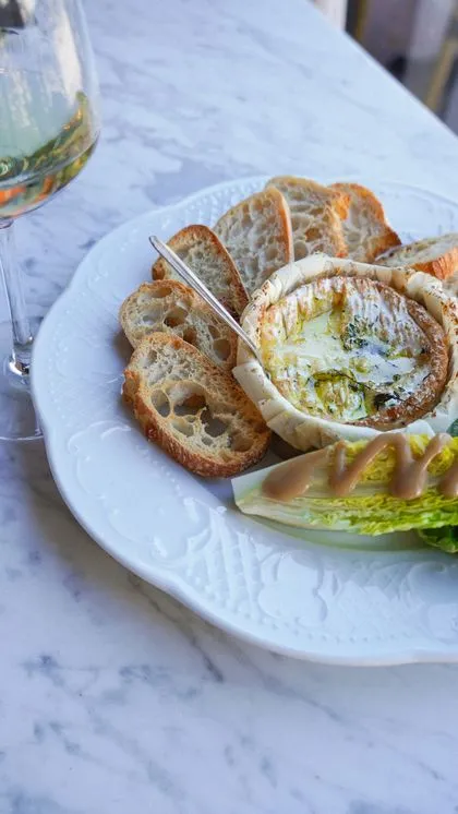 Camembert rôti et tartines, accompagné d'un verre de vin