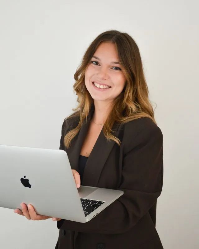Clémence, souriante, avec son ordinateur portable