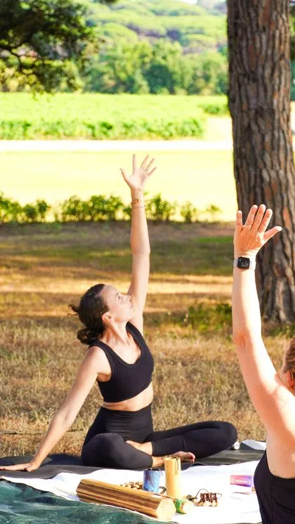 Cours de yoga en extérieur, posture bras levés