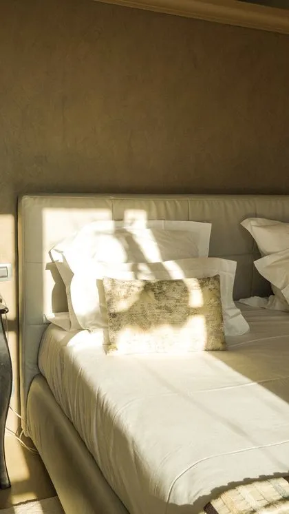 Lit cosy baigné de lumière dans une chambre d'hôtel