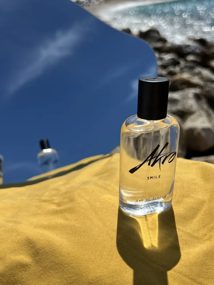 Flacon de parfum posé sur une dune de sable