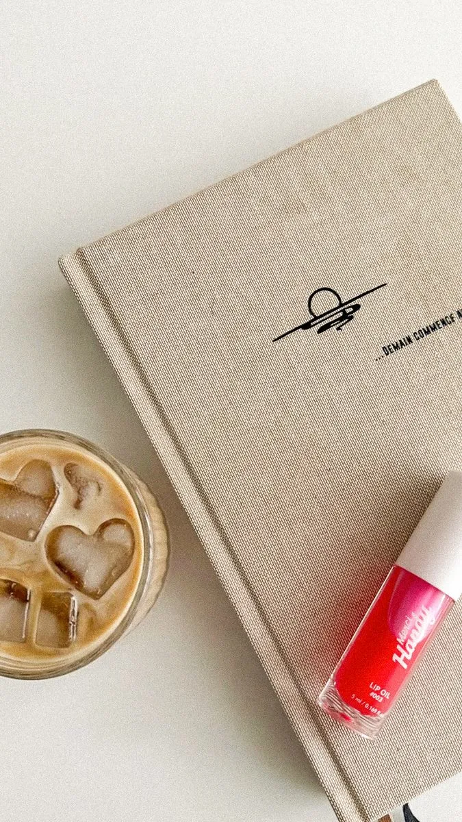 Flatlay carnet, café glacé et vernis à ongles